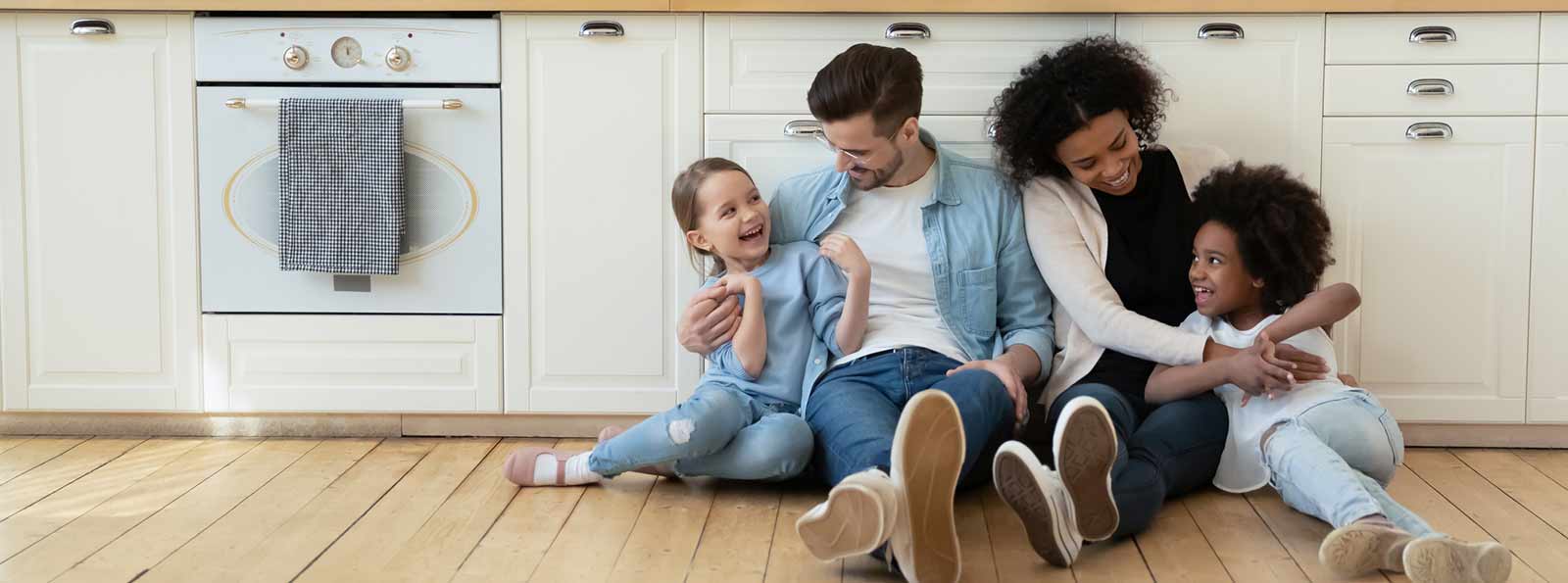 Family cuddled up together in the kitchen floor.