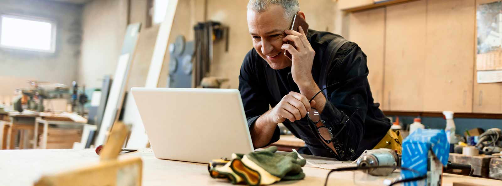 Business person on phone and in front of a laptop.